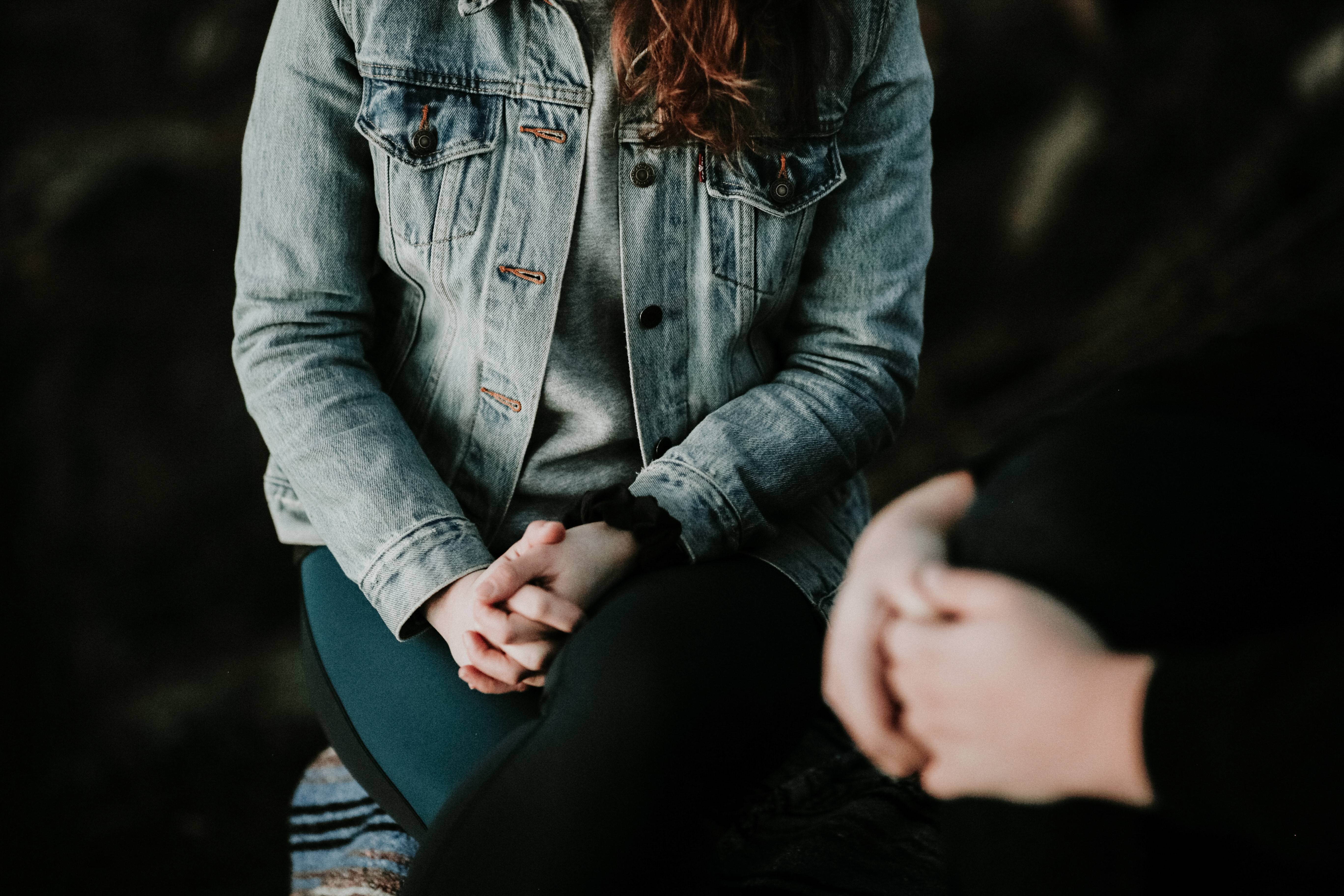 Woman sitting with clasped hands