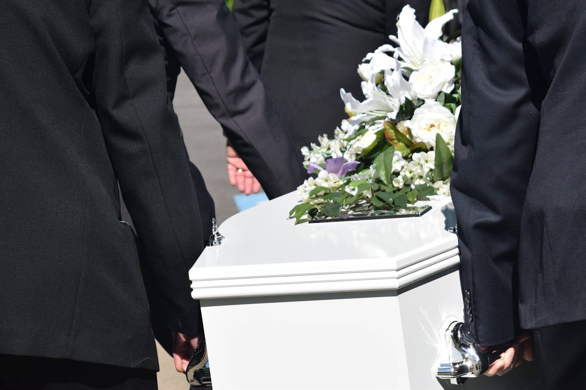 People carrying a white coffin