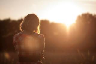 Woman looking into a sunset