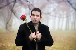 Lonely man walking with red roses