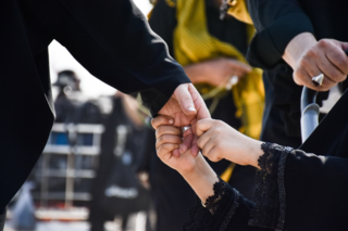 Girl holding dads hand at a funeral